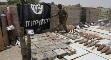 Les forces de sécurité irakiennes affichent un drapeau d`État islamique et des munitions confisquées