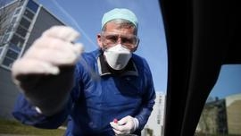 Un médecin allemand teste un automobiliste pour vérifier s'il est positif ou non au coronavirus le 27 mars 2020 à Halle, dans l'est de l'Allemagne. [Ronny Hartmann / AFP]